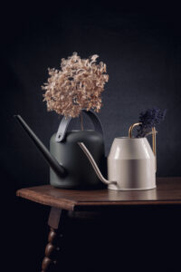 Droogbloemen in een gieter en vaas op een tafel gefotografeerd in een studio Fotograaf Deventer | Bedrijfsfotografie | Geënsceneerde fotografie | Studiofotografie