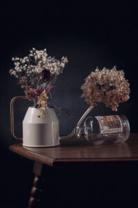 Droogbloemen in een gieter en vaas op een tafel gefotografeerd in een studio Fotograaf Deventer | Bedrijfsfotografie | Geënsceneerde fotografie | Studiofotografie