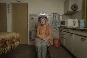 vintage portret van een oude vrouw met een droogkap in een keuken van een oud huis Fotograaf Deventer | Bedrijfsfotografie | Geënsceneerde fotografie | Studiofotografie
