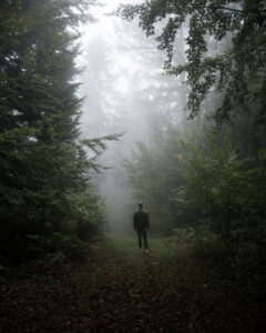 Man staat in een opening van een bos in Duitsland te kijken naar de lucht. Fotograaf Deventer | Bedrijfsfotografie | Geënsceneerde fotografie | Studiofotografie