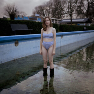 vrouw in het zwembad op een koude dag met een glijbaan op de achtergrond Fotograaf Deventer | Bedrijfsfotografie | Geënsceneerde fotografie | Studiofotografie